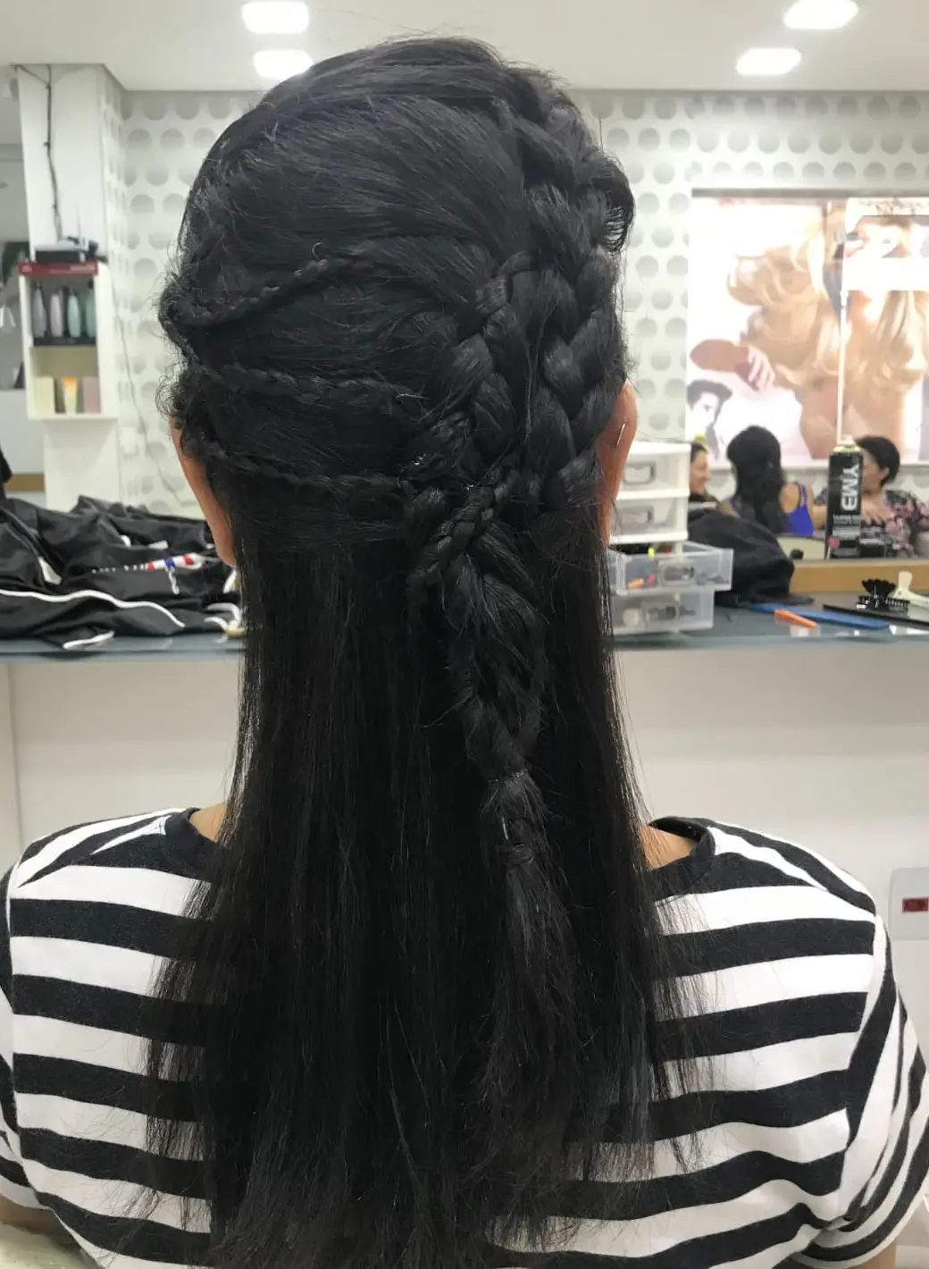 Cliente com tranças feitas na Fluir, dentro do salão no Jabaquara